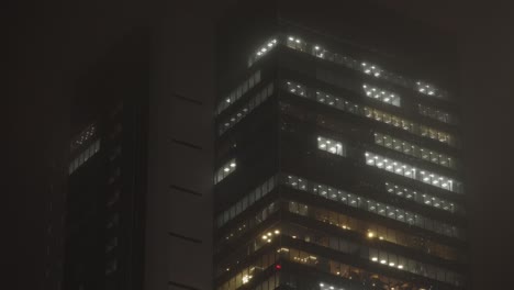 Skyscraper-Office-Building-in-Shibuya-at-Night-during-Rain,-Tokyo,-Japan