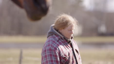 rack focus from horse to focused woman with eyes closed, equine-assisted therapy