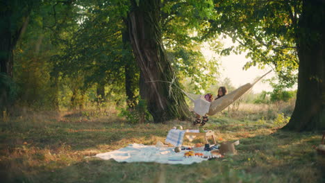 child reflects in hammock at dusk in forest