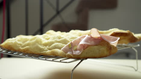 el chef está colocando una deliciosa mortadela italiana encima de un sándwich de pizza aireado y crujiente
