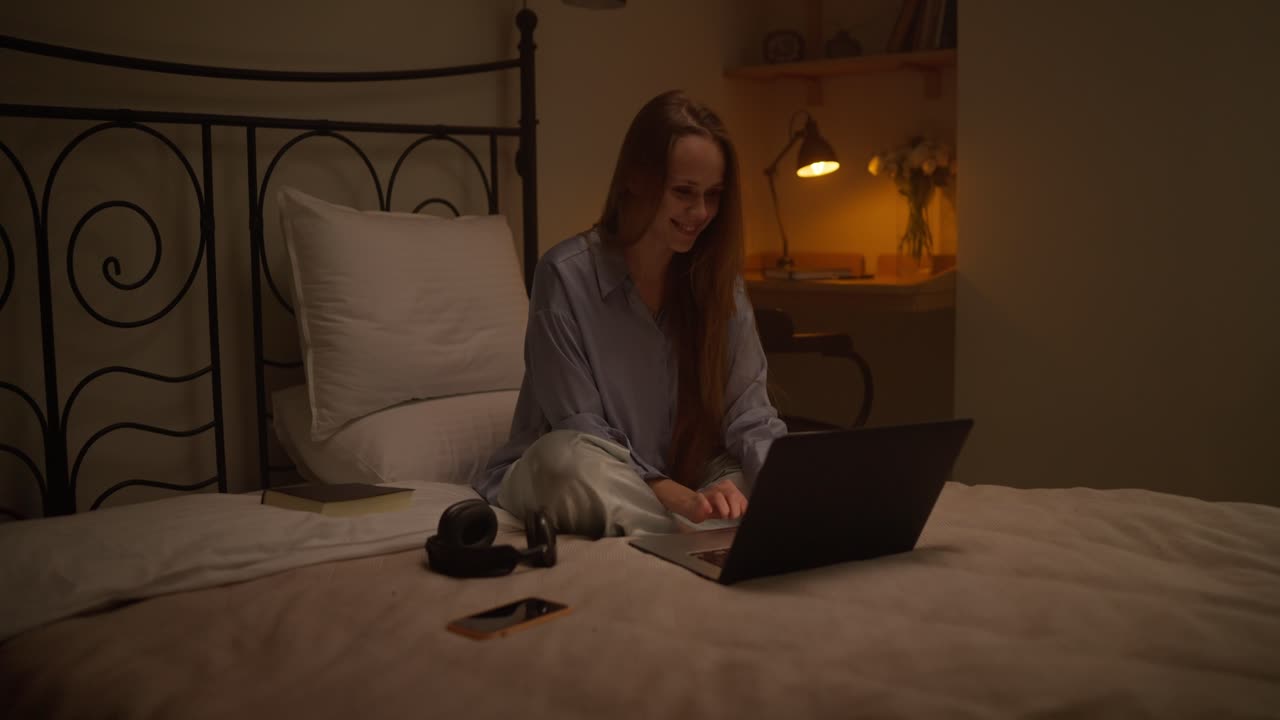 Donna che lavora al portatile a letto di notte