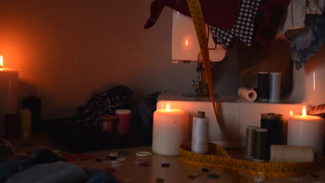 toma de fondo vintage de una máquina de coser, hilos, botones y velas, con polvo volando alrededor