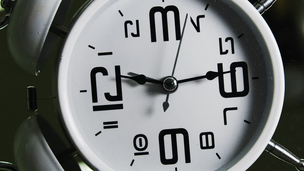 reloj despertador blanco. girar el movimiento de la cámara en dirección de la manija de minutos. loop footage. concepto de tiempo.
