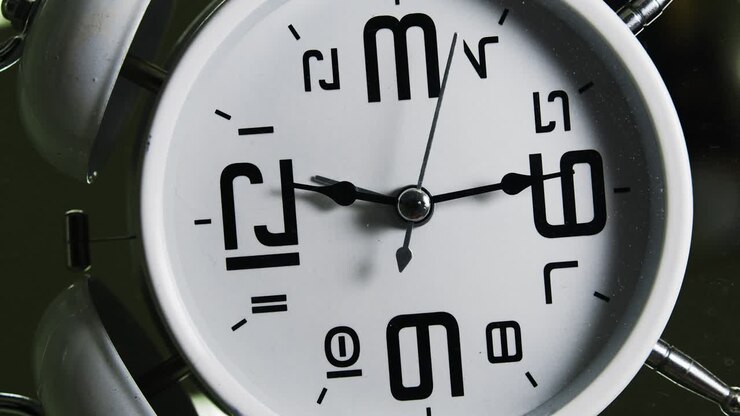White alarm clock. Turn camera movement in minute hand direction.Loop footage.Time concept.