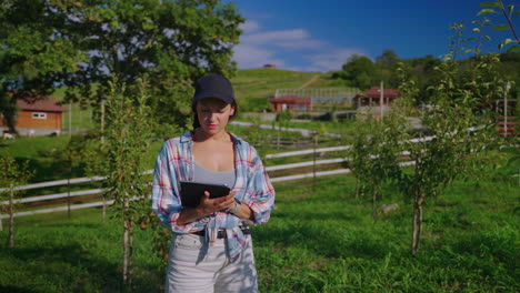 woman farmer using tablet in orchard