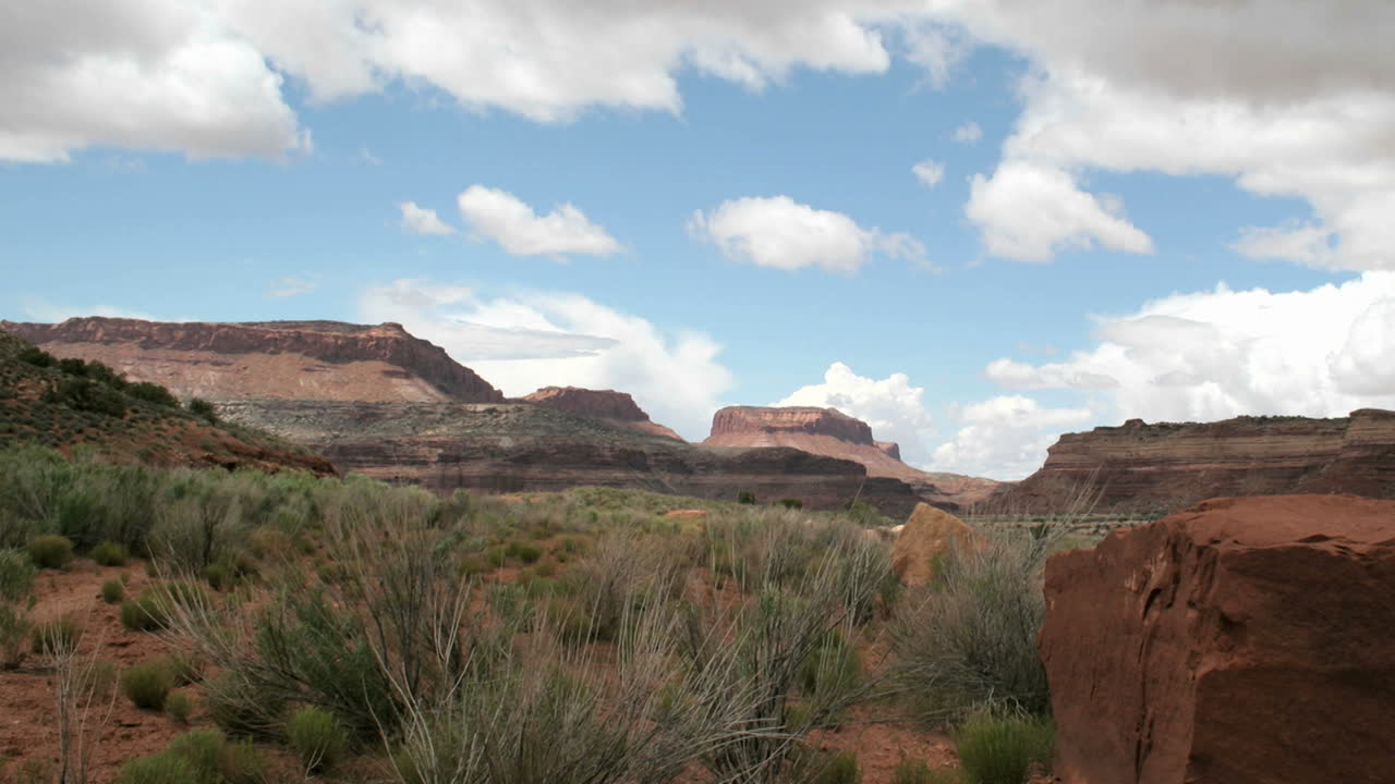 cámara lenta a la derecha de una toma de lapso de tiempo que muestra nubes pasando sobre el cañón del sombrero mexicano de utah