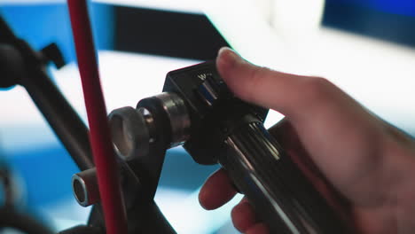 close-up of hand adjusting camera control switch with w and t settings in broadcast studio, indicating focus or zoom adjustment. camera rig setup, behind the scenes of professional filming