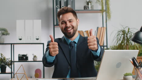 hombre de negocios feliz mirando con aprobación a la cámara mostrando los pulgares hacia arriba, como un signo positivo, buenas noticias