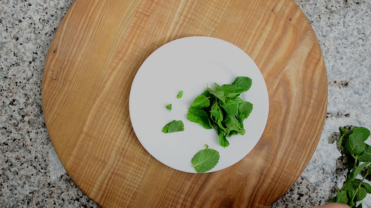 Foglie di menta su un piatto. Riprese in cucina.