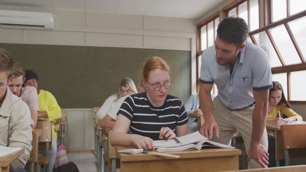 Lehrer spricht mit einem Oberstufenschüler im Unterricht