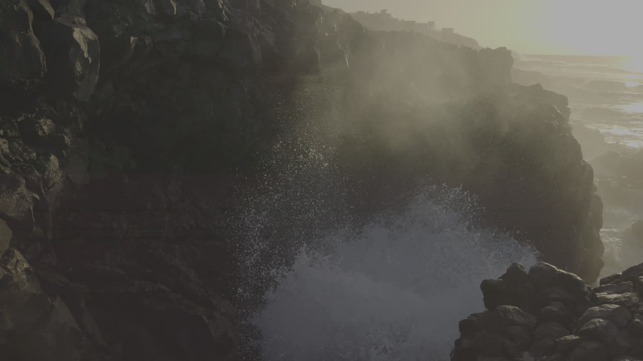 Powerful Waves Crashing Against Rocky Coastline at Golden Hour