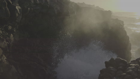 powerful waves crashing against rocky coastline at golden hour
