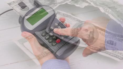 Animation-of-dollar-banknotes-falling-over-hand-of-caucasian-man-holding-payment-terminal