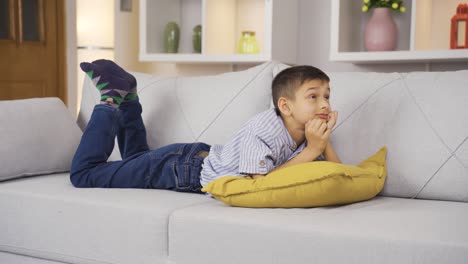 un niño soñando solo en casa.