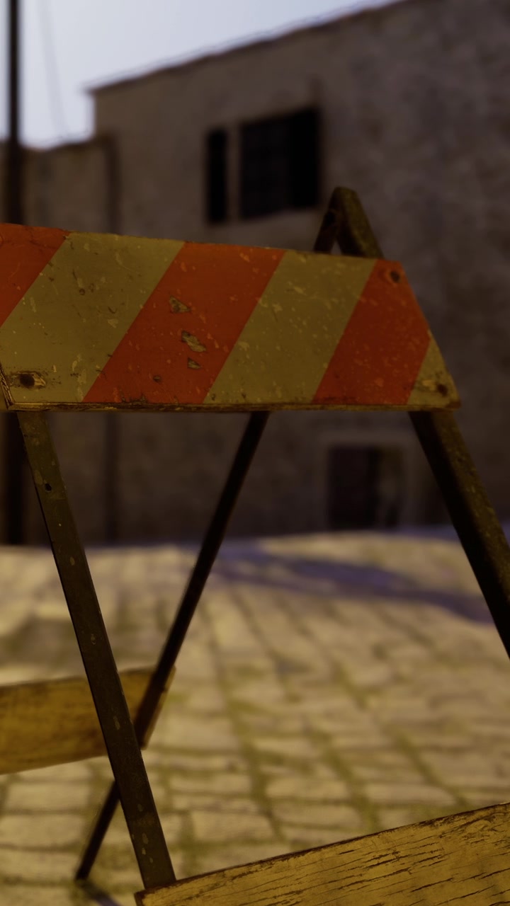 Construction barrier stands on cobblestone street at dusk in old town