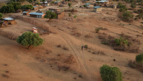 lone indigenous person is walking towards the village in karo tribe, omo valley, ethiopia