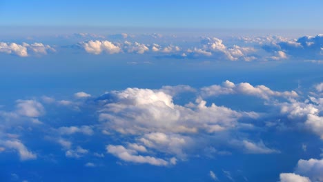 view from a plane window of beautiful white clouds floating in sky