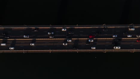 aerial top down ascend of bridge traffic lights crossing water under darkness in sydney nsw australia