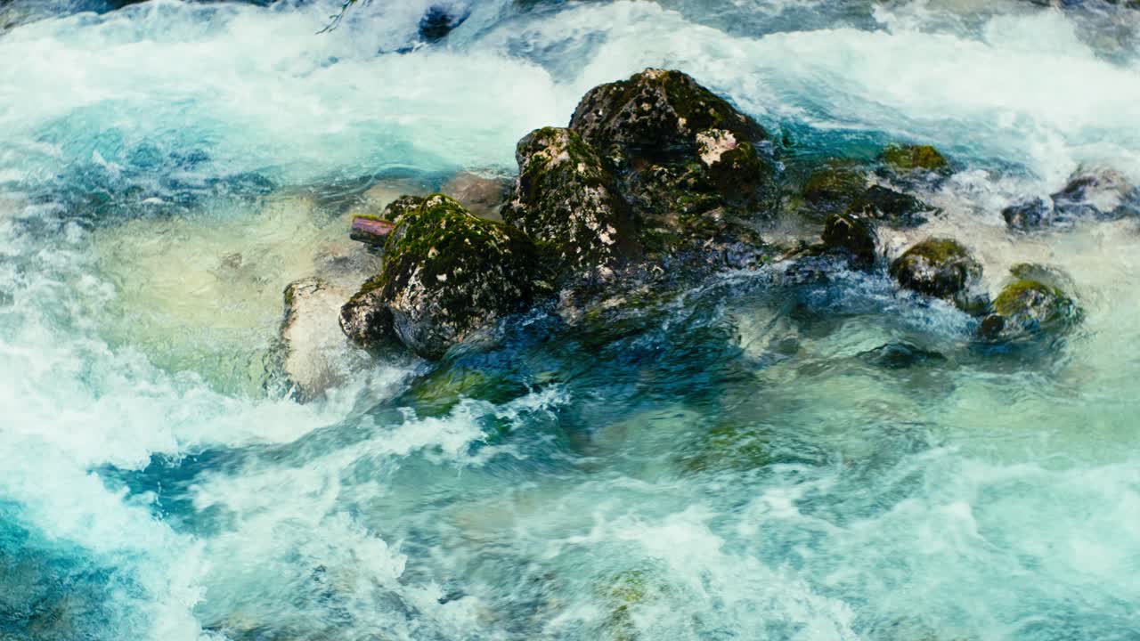 Immerse yourself in the pristine beauty of the Julian Alps with this stunning capture of a mountain river near Kranjska Gora, Slovenia. Crystal-clear turquoise water flows over smooth river rocks.