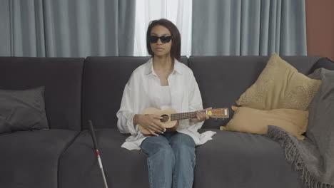 front view of young blind woman sitting on a sofa