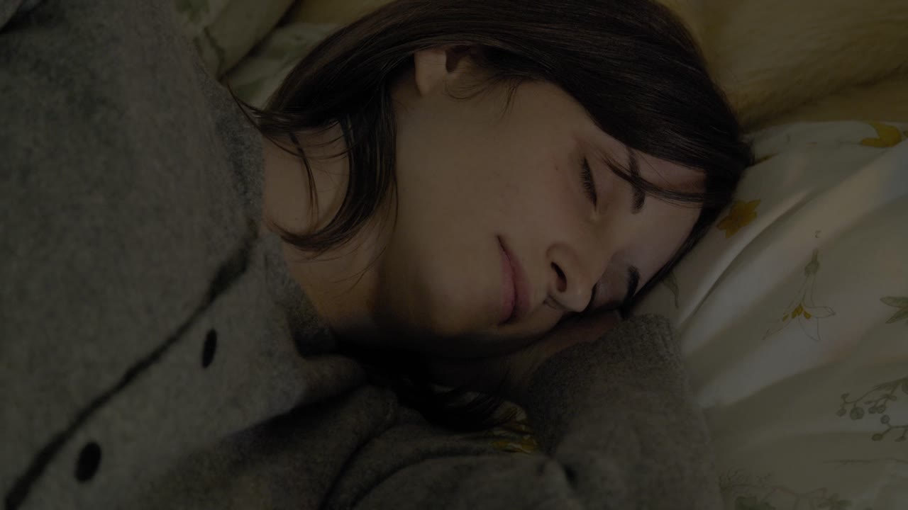 디스코 조명이 있는 침대에서 자고 있는 소녀가 가까이 있습니다.