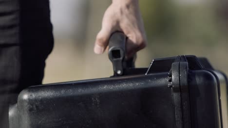 close up slow motion clip of a man carrying a heavy duty gear case