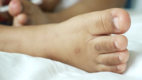 child's foot on a white sheet