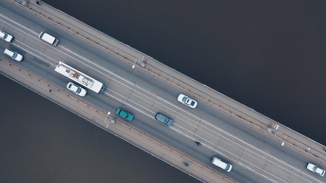 Urban car traffic on the bridge over the river. Shooting with a drone