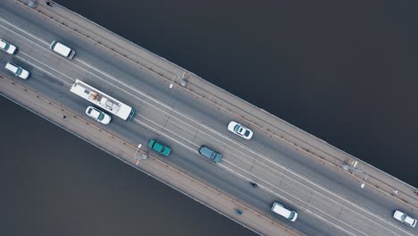 urban car traffic on the bridge over the river. shooting with a drone