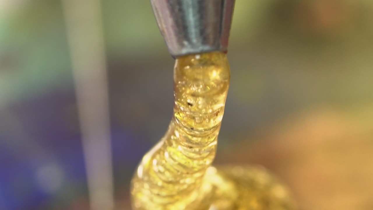 Micro bubbles in high detail macro golden hot glue dripping out macro close up