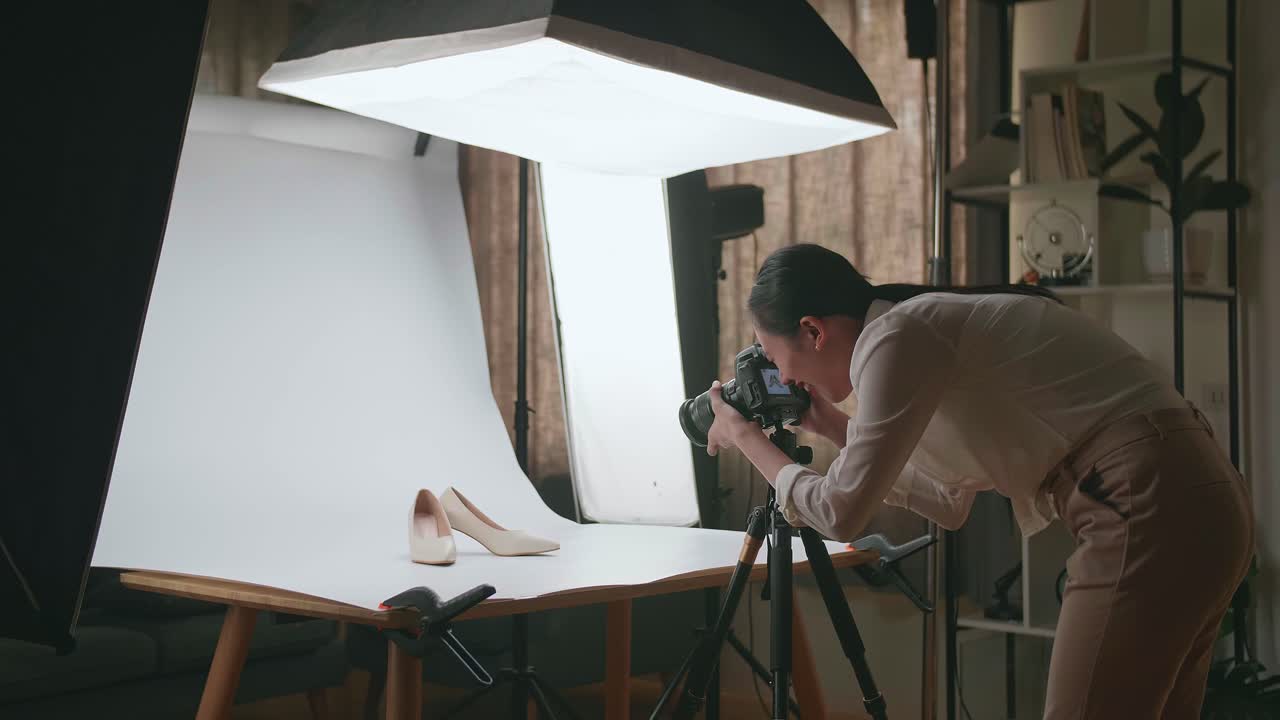 fotógrafa asiática celebra el éxito de tomar fotos de zapatos femeninos en su estudio casero