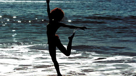 woman jumping while she is into the sea