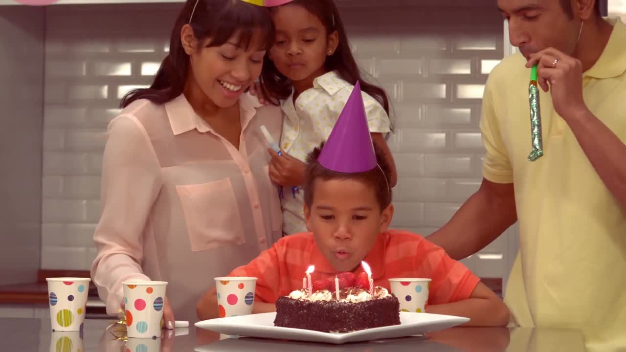 una familia hispana sonriente celebrando el cumpleaños de su hijo
