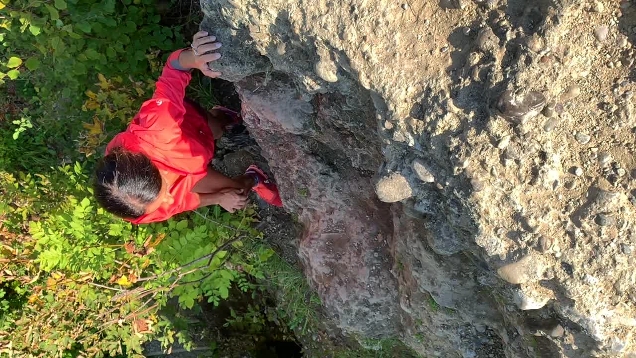 vídeo vertical en cámara lenta de una mujer mayor deportiva escalando rocas