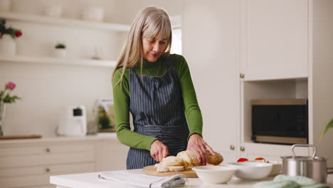 mature woman, cooking and bread in kitchen