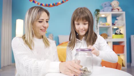 una niña linda pone dinero en su alcancía y se hace feliz.