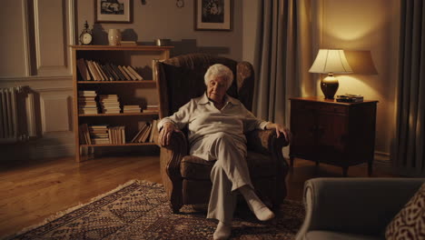 elderly woman relaxing in armchair at home