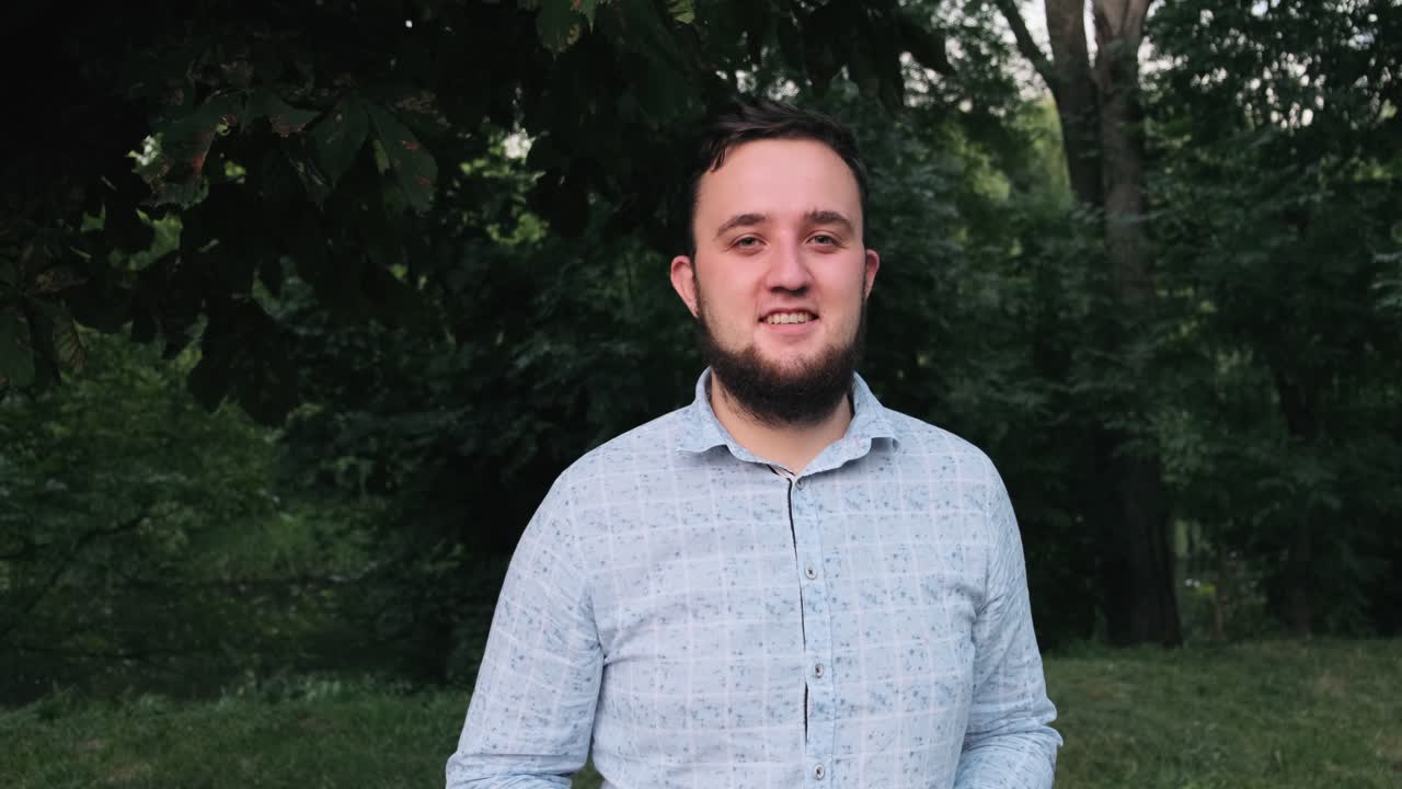 hombre con gafas sonriendo en el parque