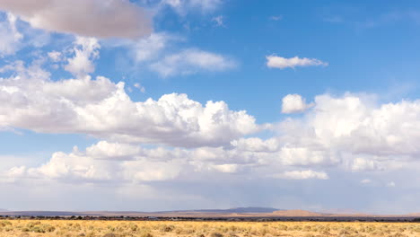 Grandes-Nubes-De-Cúmulo-Esponjosas-Son-Empujadas-Por-El-Viento-Caliente-Sobre-El-Paisaje-Del-Desierto-De-Mojave---Lapso-De-Tiempo-Estático