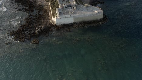 aerial view of an abandoned coastal fortress and lighthouse