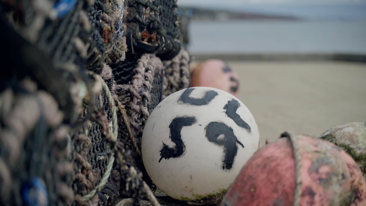 una boya de pesca comercial y redes de pesca en la playa a la espera de ser utilizadas por el pescador