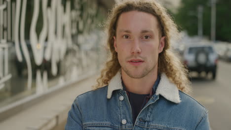 portrait of attractive young man looking at camera serious confident student lifestyle in urban city street