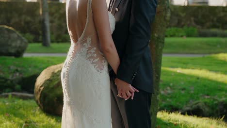 bride and groom holding hands outdoors in a green garden setting