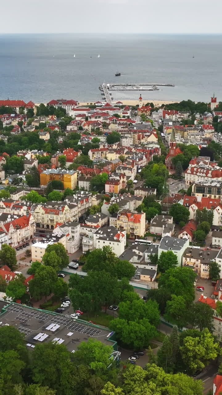 Plano vertical com drone em movimento para trás sobre a paisagem urbana de Sopot, Polônia, gaivota no quadro