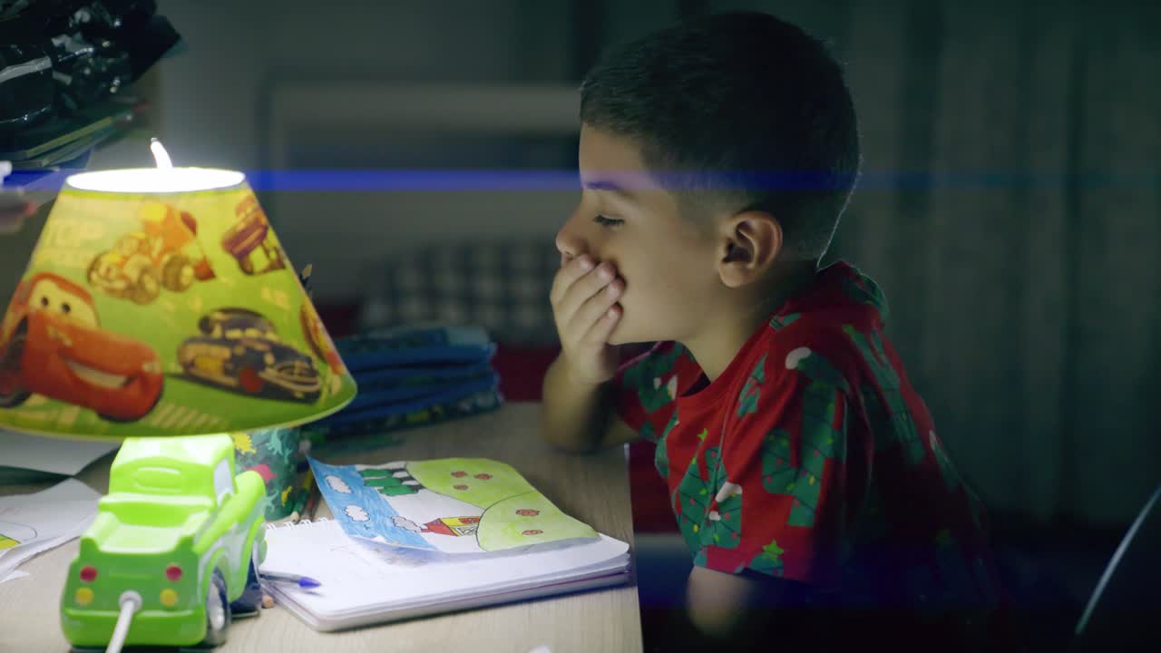 bambino stanco fa i compiti a casa di notte e dorme sulla scrivania