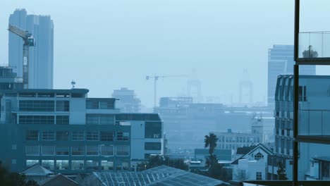 General-view-of-cityscape-with-multiple-modern-buildings-and-construction-site-with-cloudless-sky