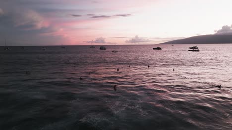 Surfistas-Disfrutando-De-Un-Cielo-Rosa-Al-Atardecer-En-El-Oeste-De-Maui,-Hawaii