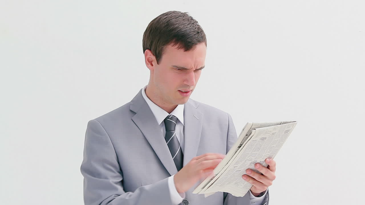 화가 난 남자가 신문을 고 있다