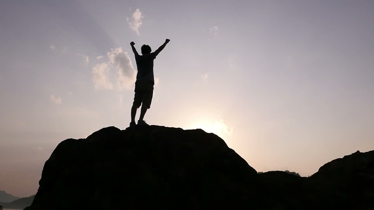 Man Celebrating on Mountain Top at Sunrise