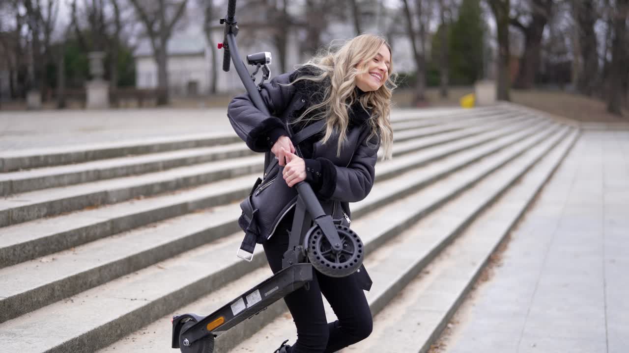 공원 의 계단 에 전기 스쿠터 를 들고 있는 여자